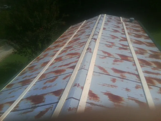 Rusted metal roof panels with new wood purlins before replacement — Storm Damage Roof Repair in Waverly by Roofing Brothers